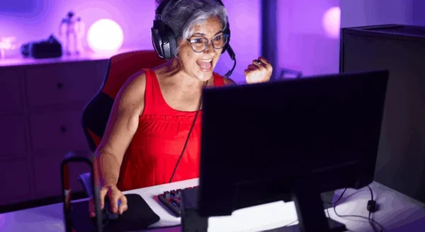 Photographie d'une grand-mère enthousiaste équipée d'un casque gaming