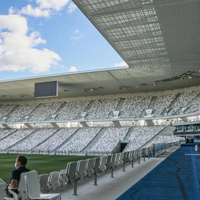 Intérieur du stade Matmut Atlantique quasi vide, avec un homme masqué assis en tribune.