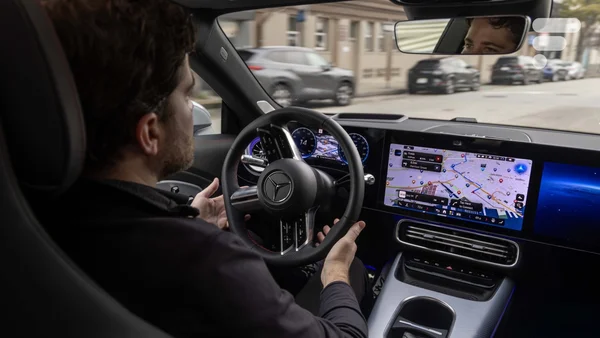 Conducteur aux commandes d'une Mercedes-Benz équipée de la technologie Nvidia, observant l'écran de navigation.
