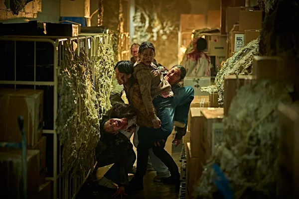 Scène du film Colony : des survivants ensanglantés dans un entrepôt.