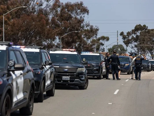 Véhicules de police et journalistes près du ruban de sécurité jaune devant le centre islamique de San Diego