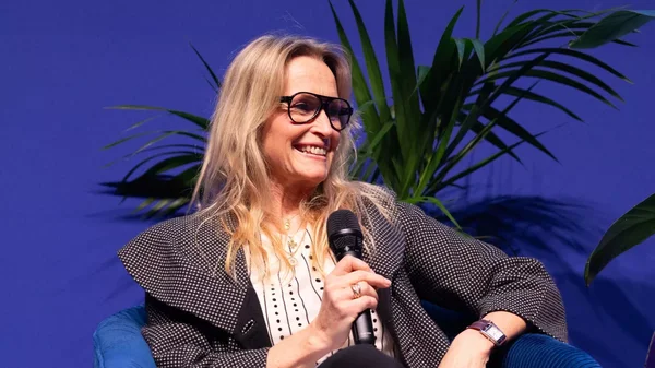 Estelle Lefébure en interview, souriante derrière un micro.