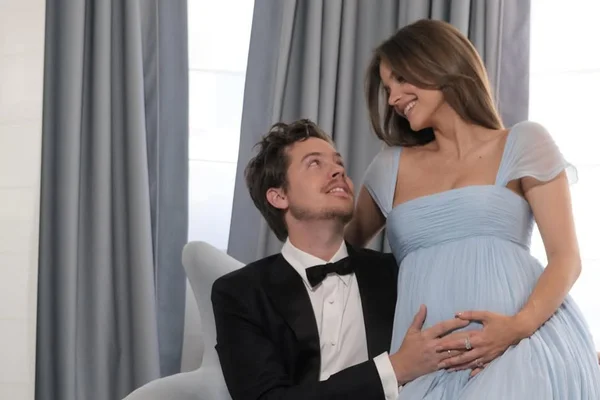 Dylan Sprouse tenant le ventre de Barbara Palvin, souriant ensemble lors de l'annonce de leur grossesse à Cannes.