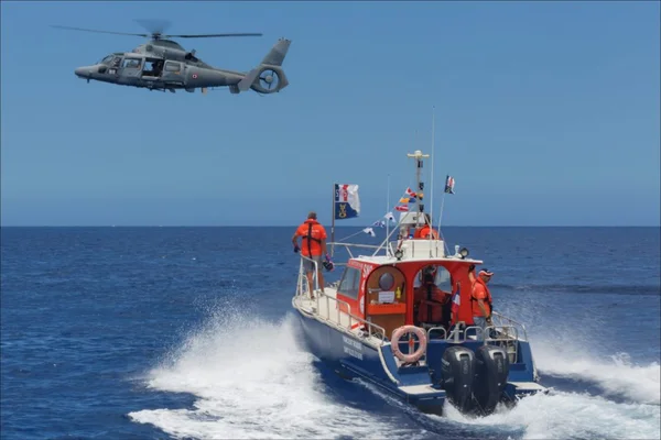 Opération de sauvetage en mer avec un bateau et un hélicoptère.