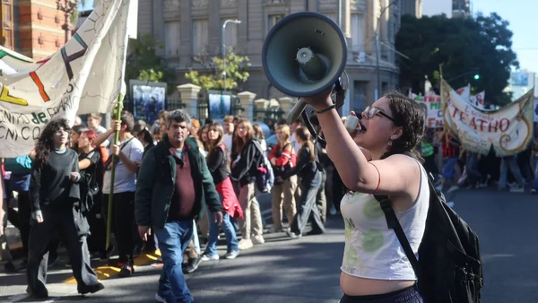 Une manifestante s'adressant à la foule avec un mégaphone lors d'une protestation pour l'université publique.