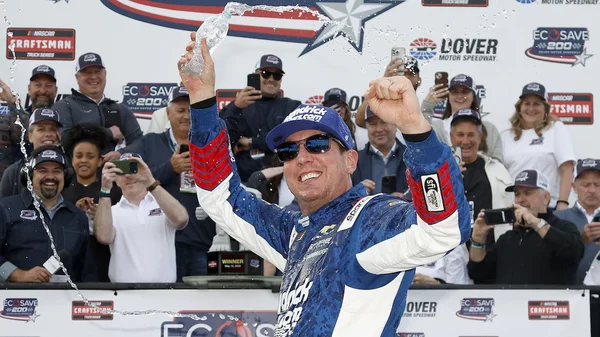 Kyle Busch célébrant une victoire avec du champagne à Dover Motor Speedway.
