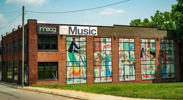 Bâtiment Moog avec fresques murales et enseigne 'moog inMusic'.