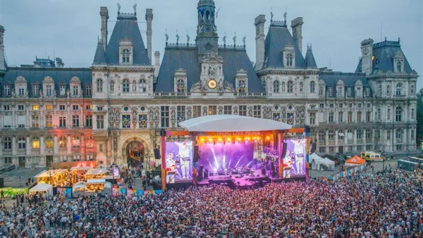 Concert en plein air devant un bâtiment parisien, illustrant l'ambiance des festivals gratuits de l'été.
