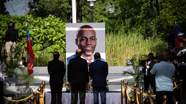 Personnalités devant un portrait de Jovenel Moïse lors d'un hommage.