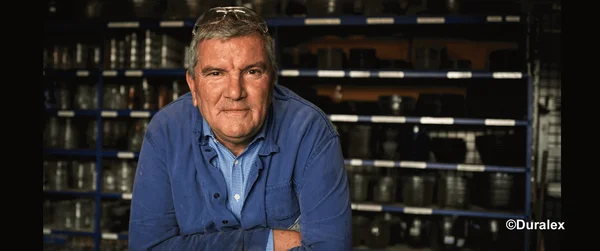 François Marciano dans l'usine Duralex, entouré de verrerie.