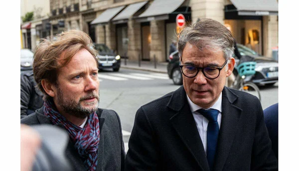 Boris Vallaud et un autre homme discutant dans la rue.