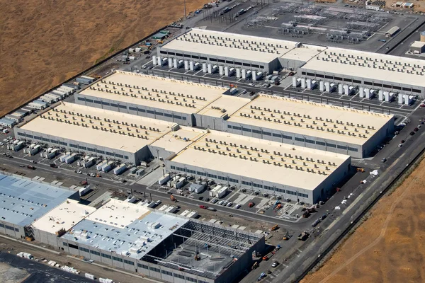Vue aérienne d'un centre de données dans un paysage aride, illustrant l'empreinte industrielle de ces infrastructures.