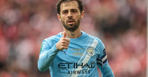 Bernardo Silva souriant et faisant un pouce levé avec le maillot de Manchester City.