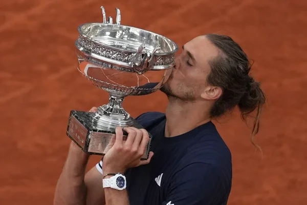 Alexander Zverev embrassant le trophée de Roland-Garros 2026 après sa victoire en finale.