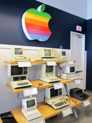 Collection d'ordinateurs Apple historiques (1979-1989) sous le logo arc-en-ciel de la marque.