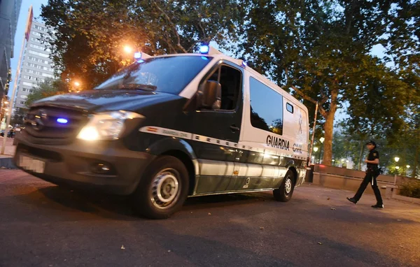 Véhicule de la Guardia Civil en patrouille urbaine au crépuscule.