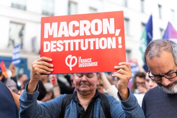 Manifestant avec une pancarte « MACRON, DESTITUTION ! » lors d'une protestation.