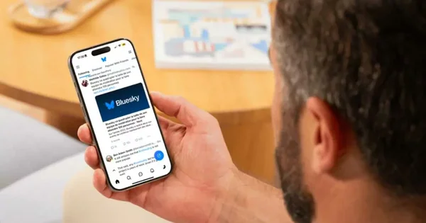 Un homme consulte l'application Bluesky sur son smartphone.