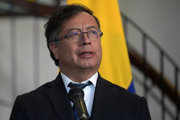 Gustavo Petro s'adressant à la presse, drapeau jaune en arrière-plan.