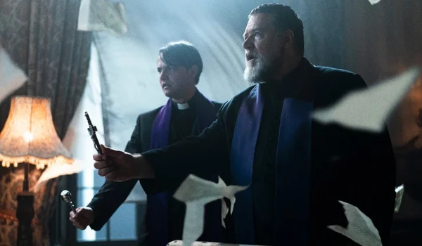 Scène dramatique d’une production télévisuelle montrant deux hommes d’Église en tenue ecclésiastique, entourés de papiers volants.