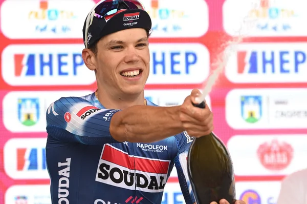 Paul Magnier fêtant une victoire avec du champagne sur le podium.