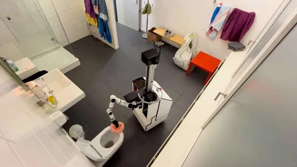 Bras robotique de nettoyage de toilettes en action dans une salle de bain.