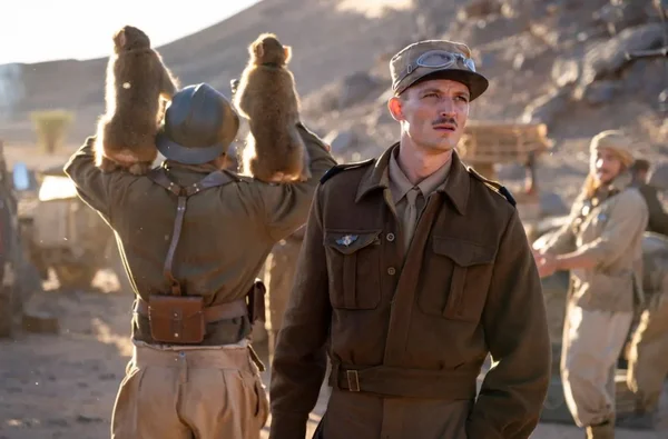 Scène du film 'La Bataille de Gaulle' avec un soldat et deux singes dans le désert.