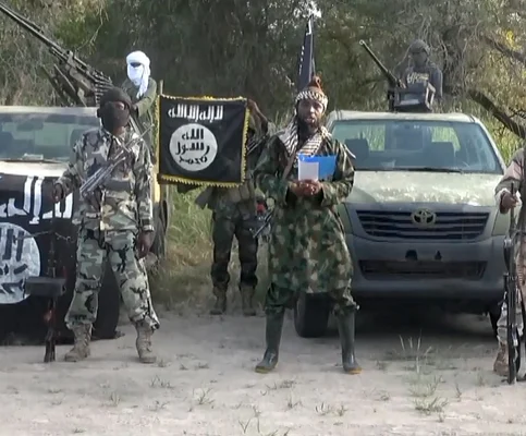 Hommes armés de l'armée nigériane près de véhicules, avec un drapeau de Boko Haram visible.
