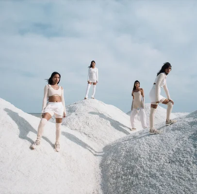 Mannequins dans la campagne Jacquemus x Nike, sur fond de paysages minéraux évoquant l'été.