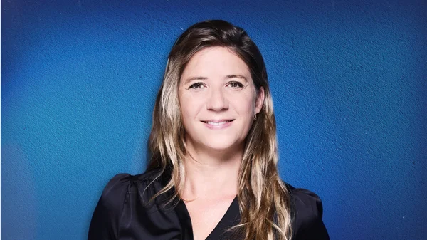 Portrait de Stéphanie de Monaco aux cheveux longs ondulés et mèches blondes.