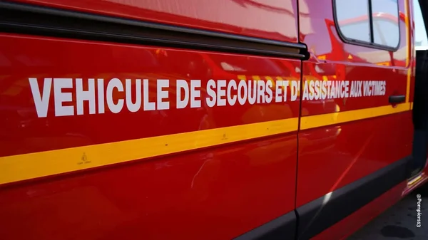 Véhicule de secours rouge avec inscription 'VÉHICULE DE SECOURS ET D'ASSISTANCE AUX VICTIMES'.