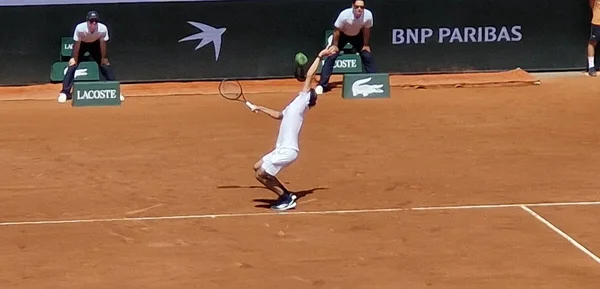 Un joueur de tennis au service sur le court de Roland-Garros.