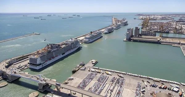 Vue aérienne du port de Barcelone avec plusieurs paquebots de croisière amarrés.