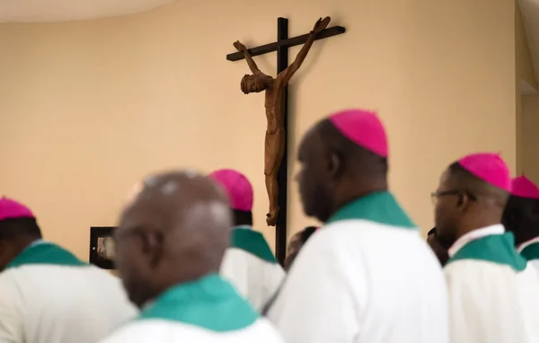 Évêques catholiques en prière devant un crucifix.
