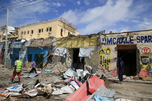 Des bâtiments dévastés par les combats dans une rue de Mogadiscio, avec des civils se déplaçant parmi les décombres.
