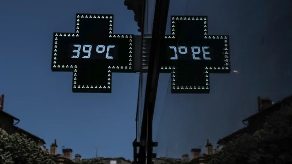Reflet d'une enseigne de pharmacie indiquant 39°C, symbole des fortes chaleurs.