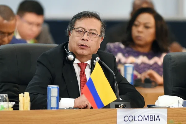 Gustavo Petro lors d'une conférence, entouré du drapeau colombien.