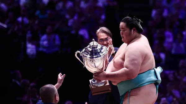 Kotozakura brandissant le trophée du Tournoi de Paris de sumo.