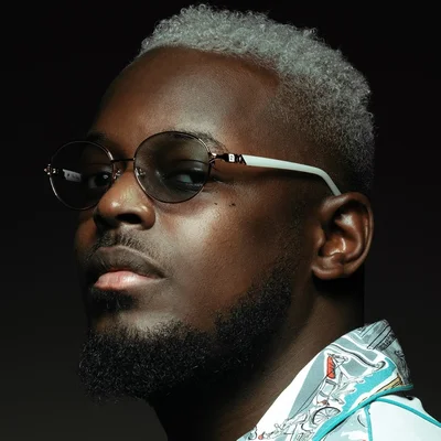 KeBlack en gros plan, style décontracté et lunettes rondes.