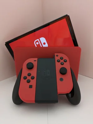 La Nintendo Switch rouge dans son socle, avec la boîte du système en arrière-plan.