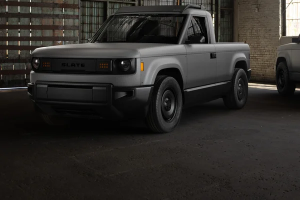 Pick-up électrique Slate Auto gris mat dans un entrepôt industriel.