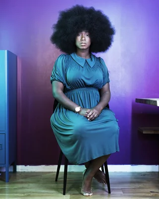 Assa Traoré, égérie Louboutin, assise dans une pose élégante.