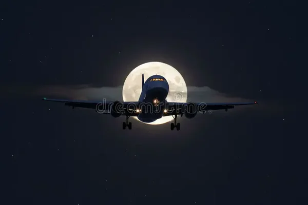 Avion commercial volant devant une pleine lune la nuit photos libres de droits