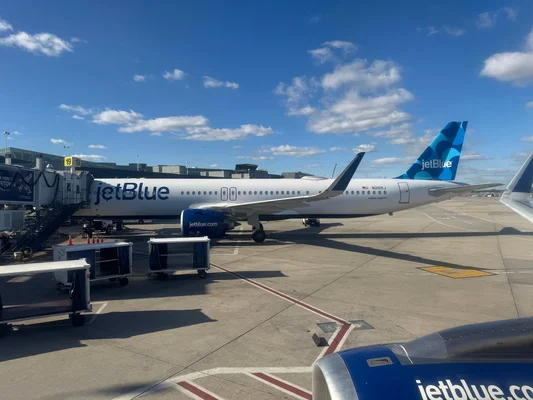 Un Airbus A321 de JetBlue à son poste de stationnement, relié à la passerelle.
