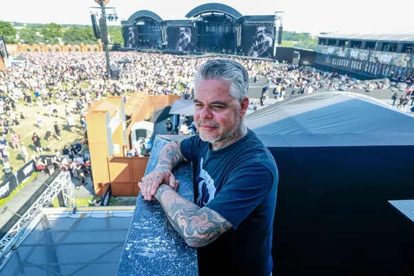 Un festivalier tatoué observe la foule au Hellfest.