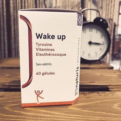 Boîte de 'Wake up' de Bonaturis sur une table en bois, à côté d'un réveil.