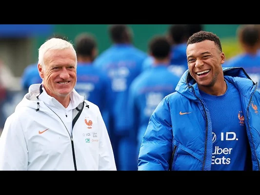 Didier Deschamps et un membre du staff souriant lors d'un entraînement.