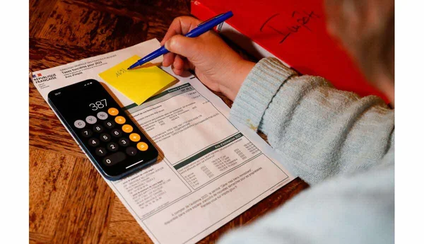 Contribuable remplissant son avis d'impôt, smartphone affichant 387.