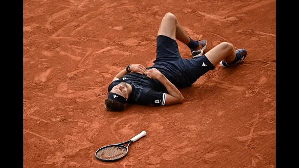 Alexander Zverev allongé sur la terre battue, célébrant sa victoire à Roland-Garros.