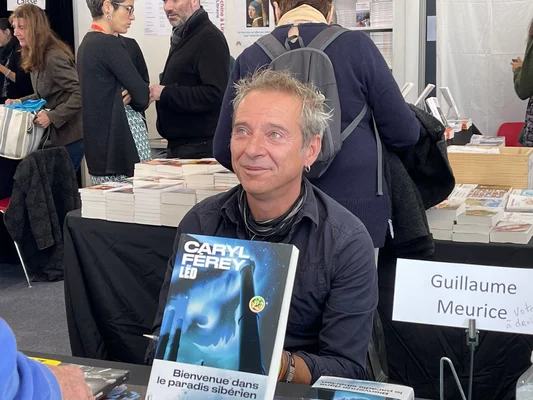 Caryl Férey dédicace ses romans lors du Salon Lire en Poche 2021.